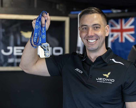 Jedi Roberts, founder of JEDX10 Christchurch Personal Training, holding a medal.